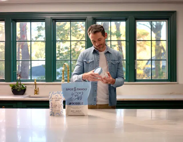 Man in his home with Spot and Tango products